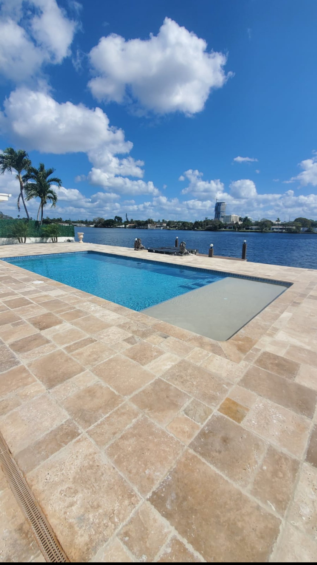 Waterfront pool with travertine deck